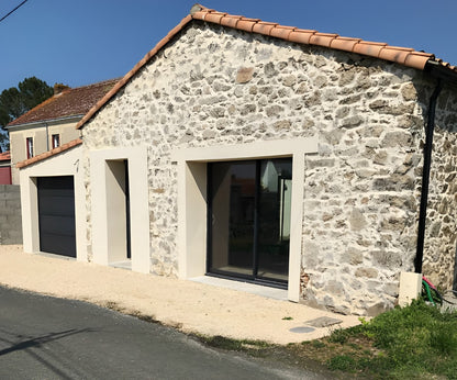 Vue extérieure côté rue d’une grange transformée en maison moderne